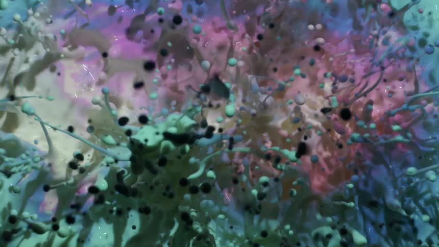 Blue and pink pastel colors reflect in a moving liquid as a black organic substance moves among the spheres