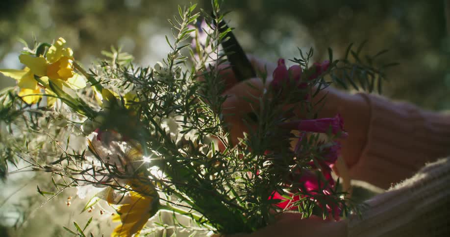 A woman arranges flowers in her hand