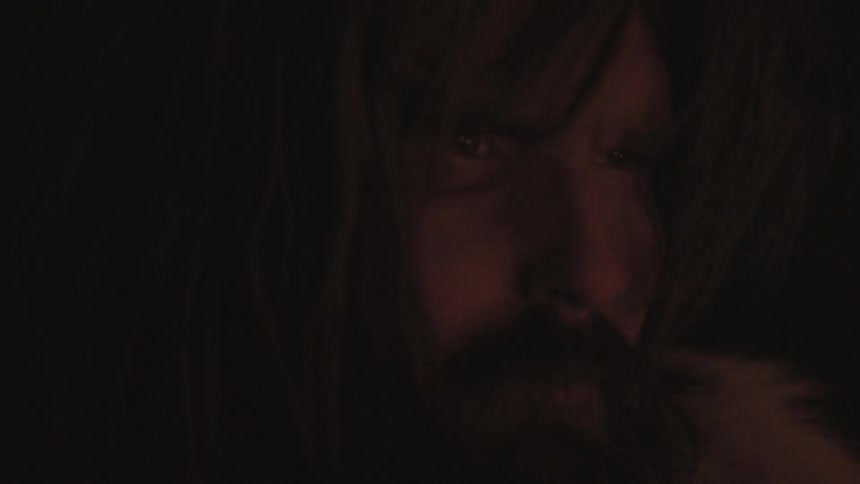 A man is standing in a dark area looking forward