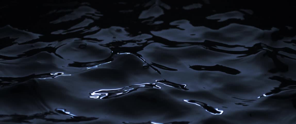 Close up of ripples and small waves on the surface of dark waters