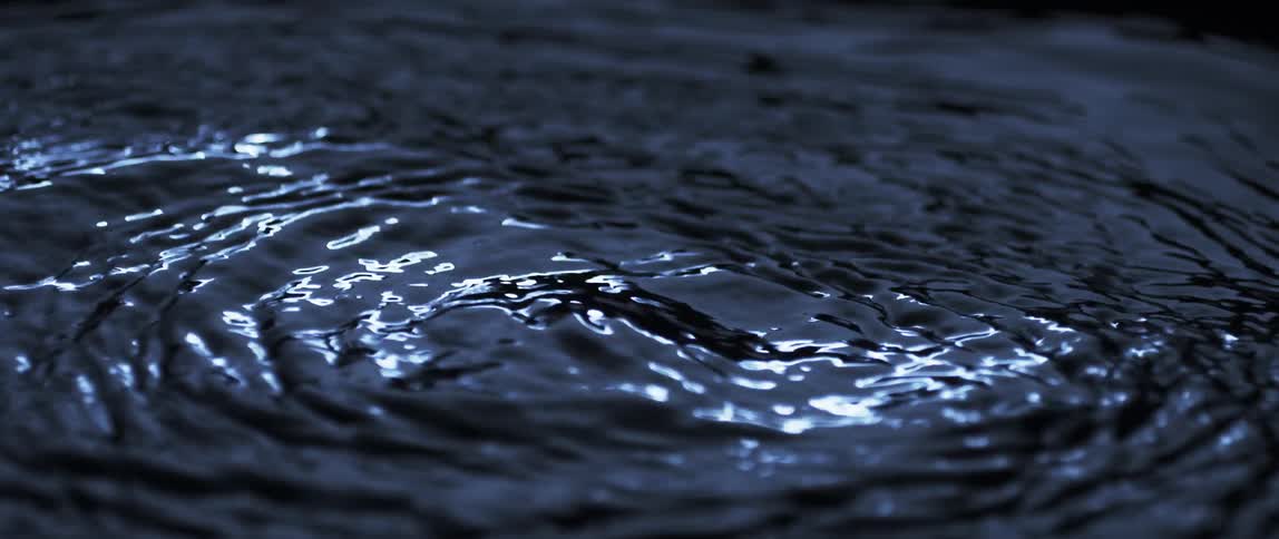 Light shines and reflects on liquid as it ripples and moves