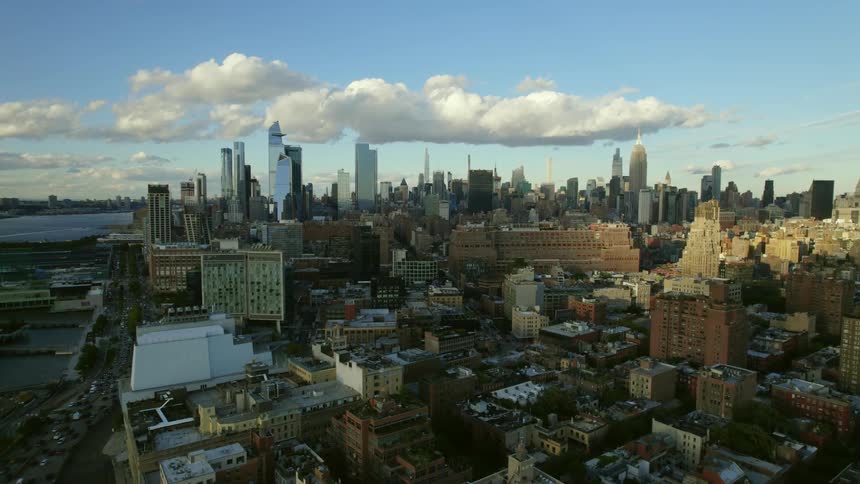 An aerial view of apartment and office buildings in a city with cars driving on streets