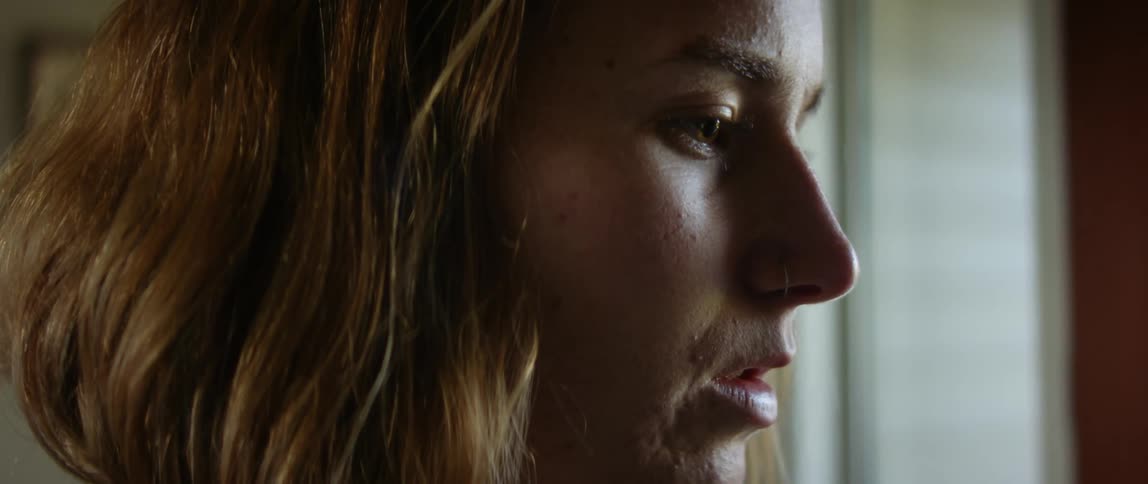 Side profile of blonde woman with wavy hair looking into space