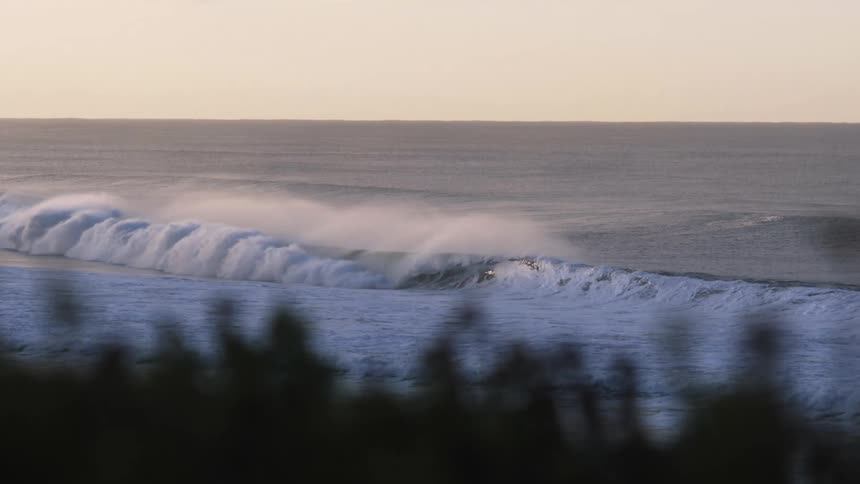 Ocean wave breaks against the beach