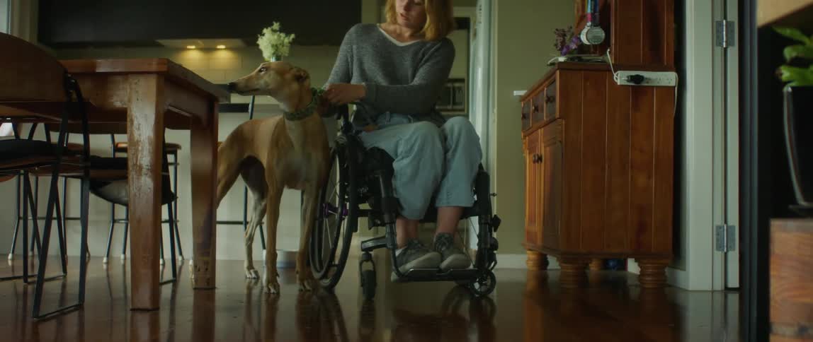 A woman in a wheelchair heading out with her dog