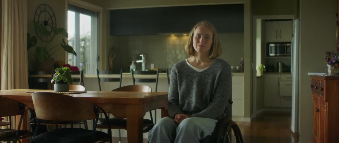 A woman is sitting in a chair in her house