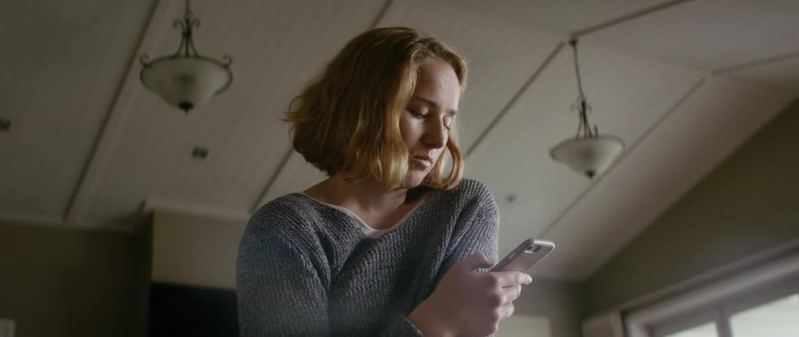 A woman is texting on her cellphone indoors