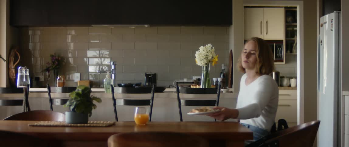 A woman is eating food in her kitchen