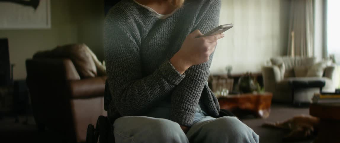 A woman is sitting down and looking at her cellphone