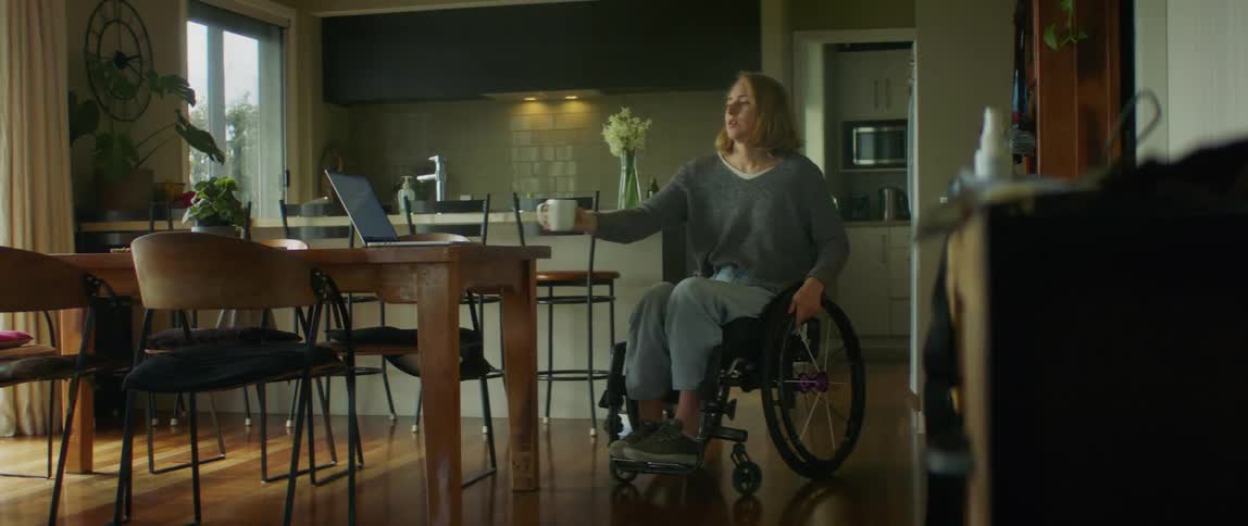 A woman is at the table with her laptop