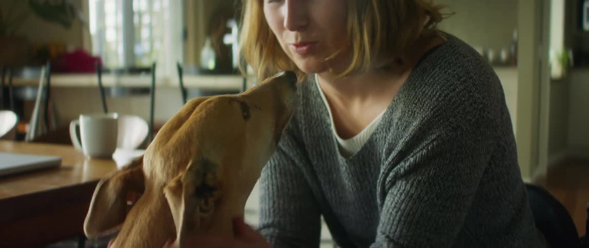 A woman is petting her dog indoors