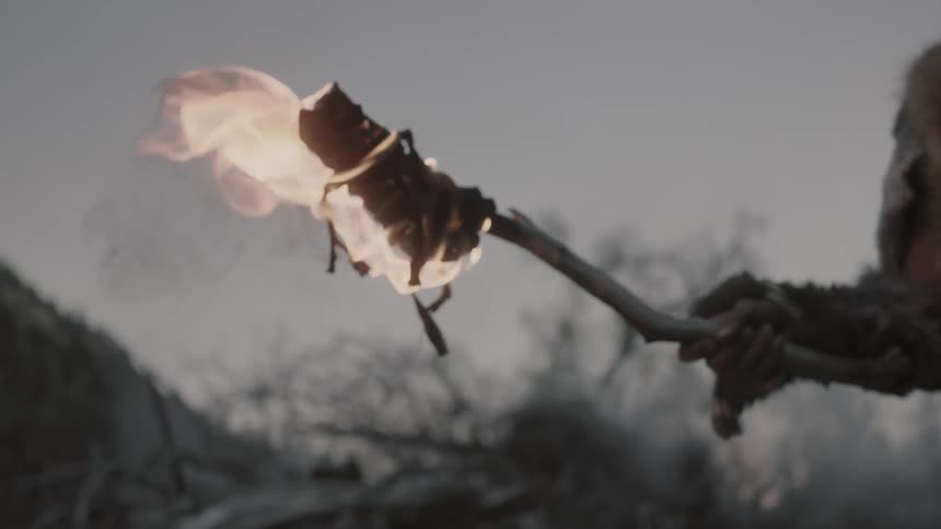 A man holds a torch outside