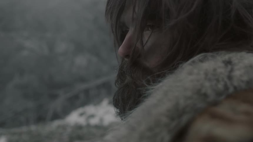 Bearded wilderness man looking around in a smoky area