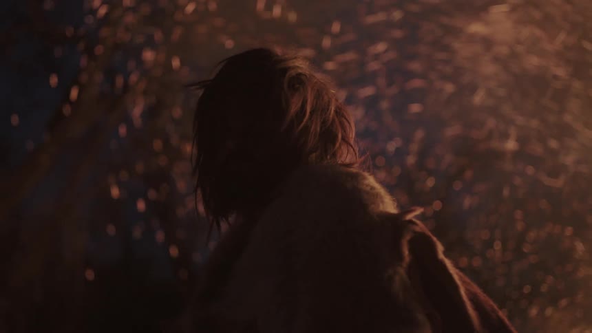 A man stands near a sparking fire