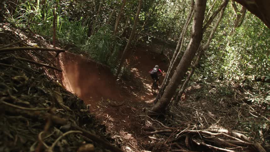A person speeding down a dirt trail on a mountain bike