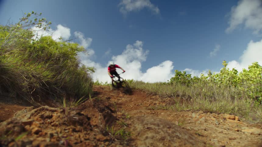 A person mountain bikes down a dirt hill