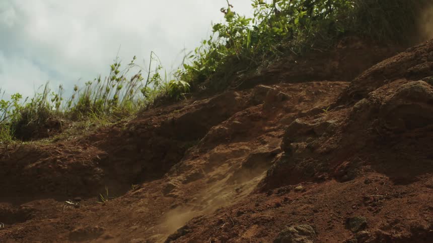 A person mountain bikes down a dirt hill
