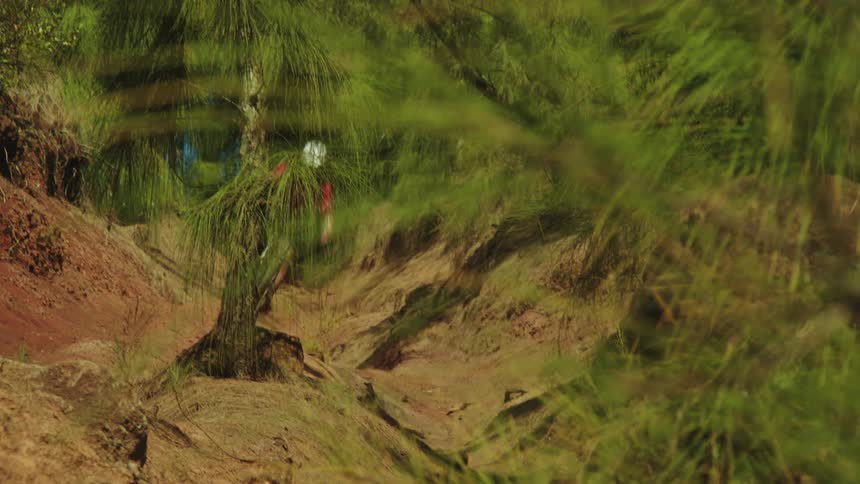 A cyclist rides down rough terrain in a canyon