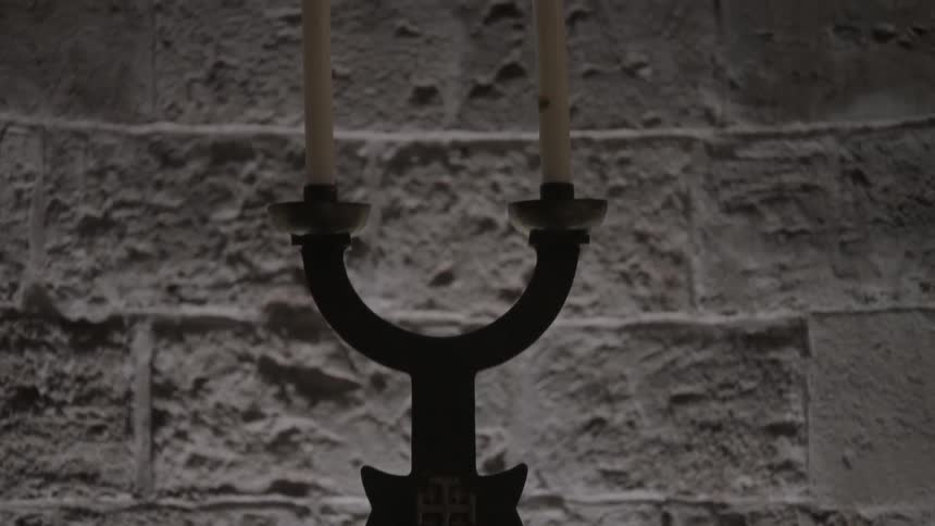 Candelabra sitting in front of a religious portrait