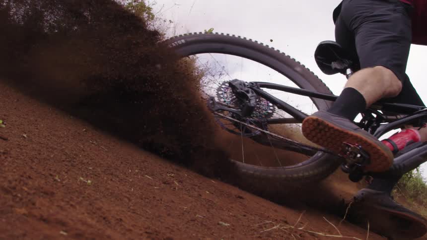 A man mountain bikes down a dirt hill