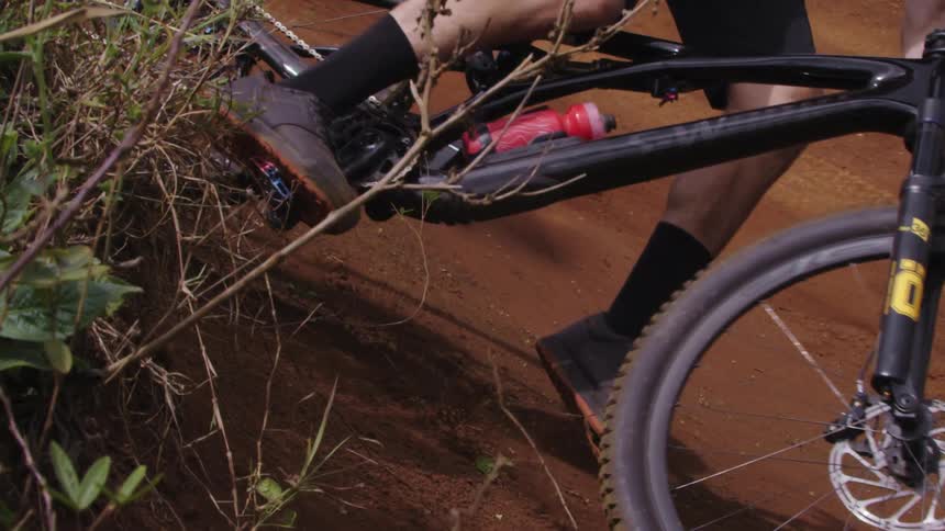 A man taking a tight turn on a hillside on a mountain bike