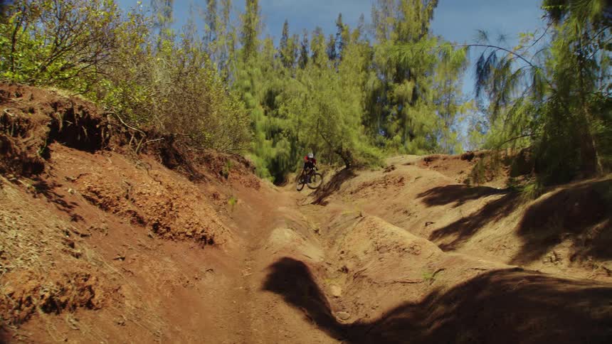 A man riding a mountain bike over a dirt trail