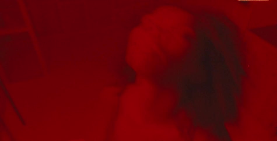 A woman dancing and drinking with strobing lights