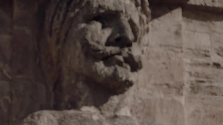 A man's face carved in a stone wall