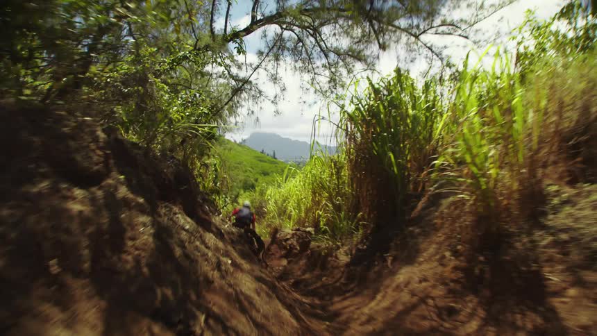 A man is riding a dirt bike downhill during spring