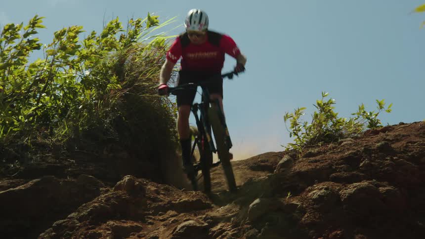 A person is biking downhill through nature