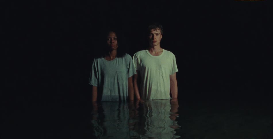 A man and woman stand side by side behind a table