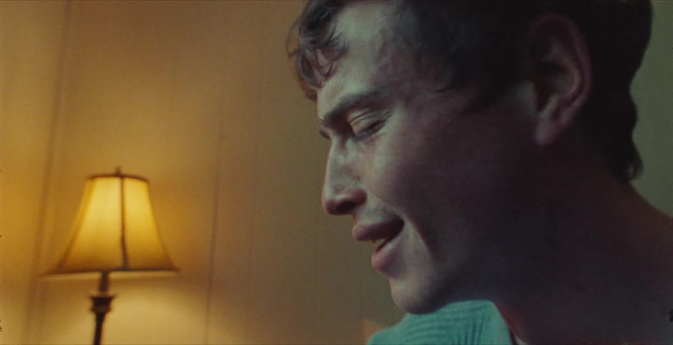Sad young man and woman crying while sitting next to each other near the window in a bedroom