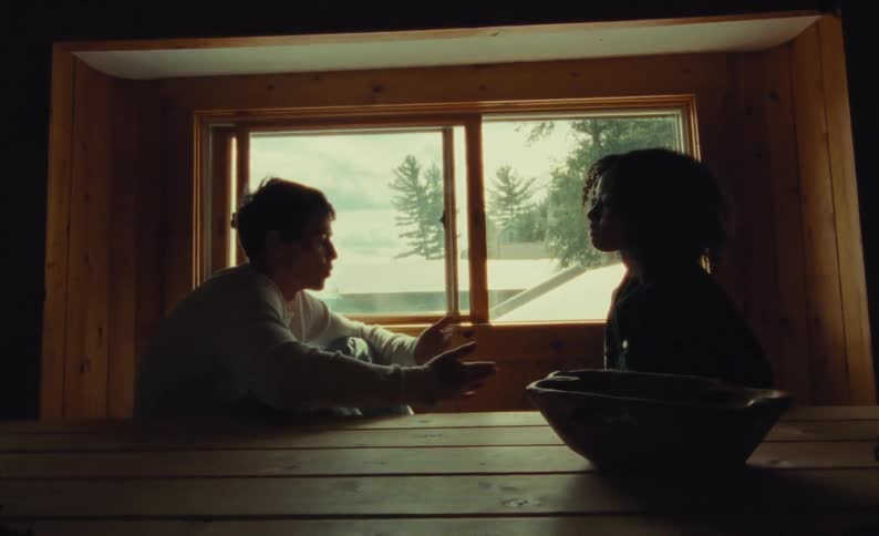 A teenage boy and girl sit in a house and argue