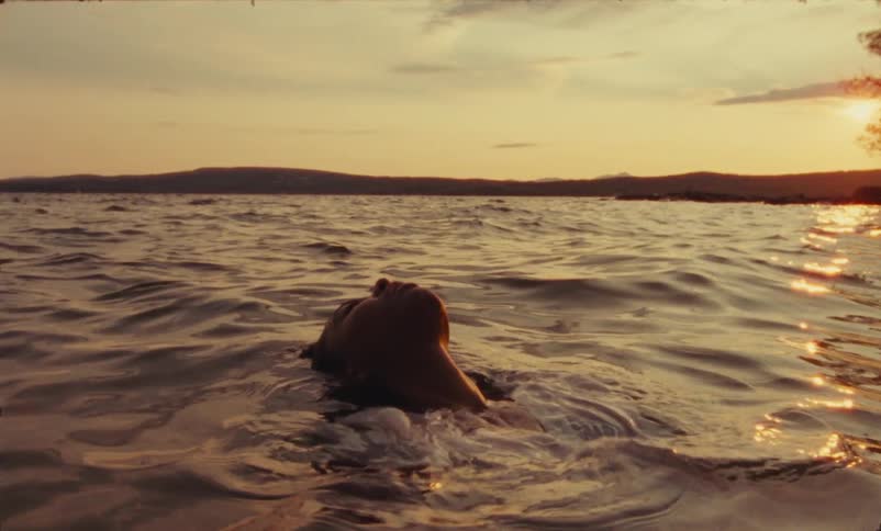 A woman wears a t shirt while floating in the sea on her back
