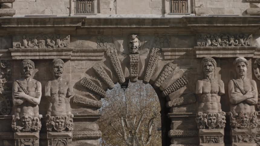 A stone arch is adorned with friezes and statues