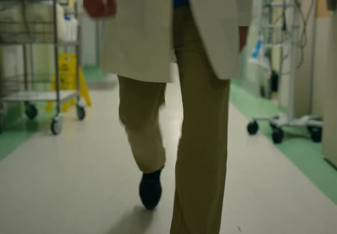 Doctor walks along hospital corridor