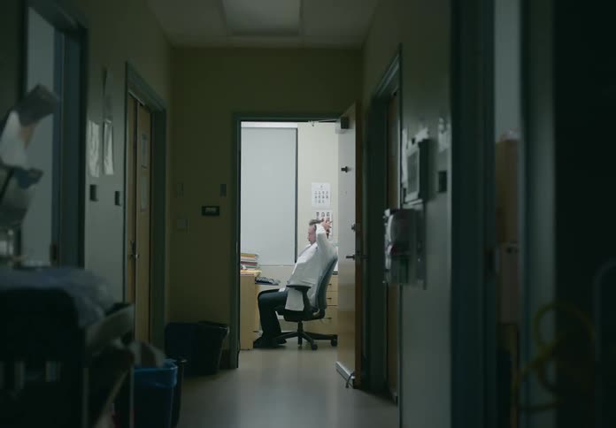 A man is sitting in his office and looks stressed