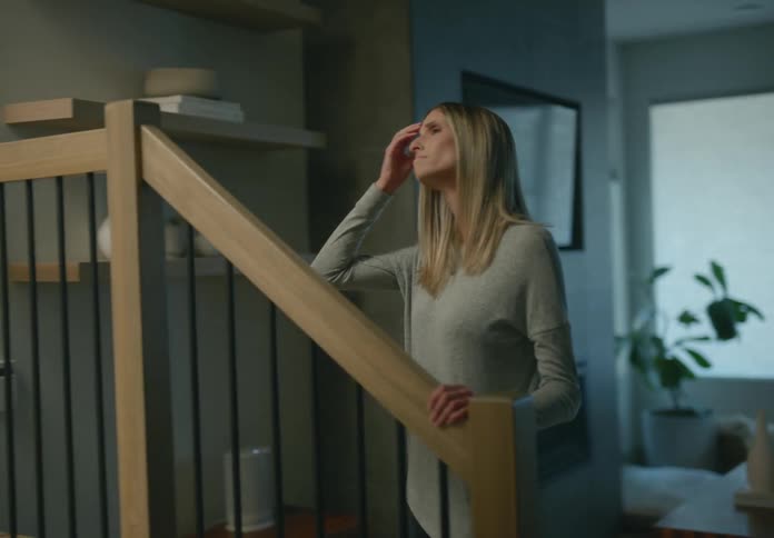 A teenage girl is arguing with her mother and she goes up the stairs as her mother has her hand on the rail looking up