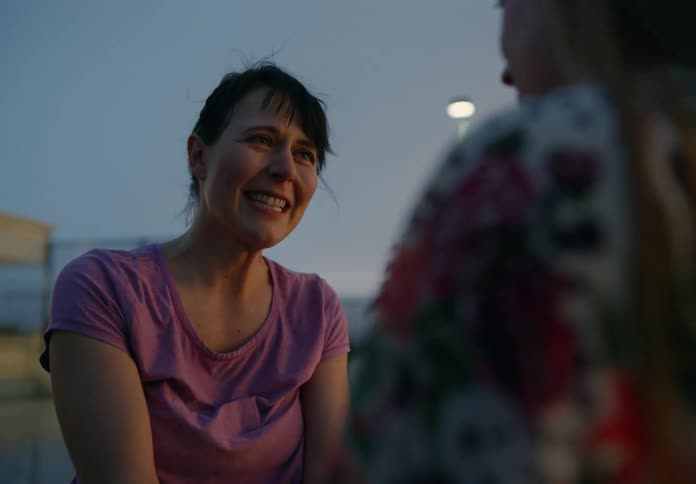 Two female adult friends meeting in a public place hugging each other while crying of joy with great happiness