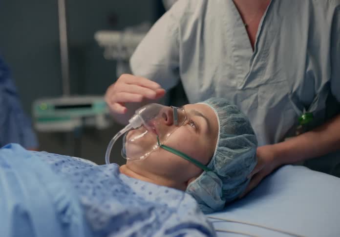 Surgeon puts a mask over a patients face on the operating theatre