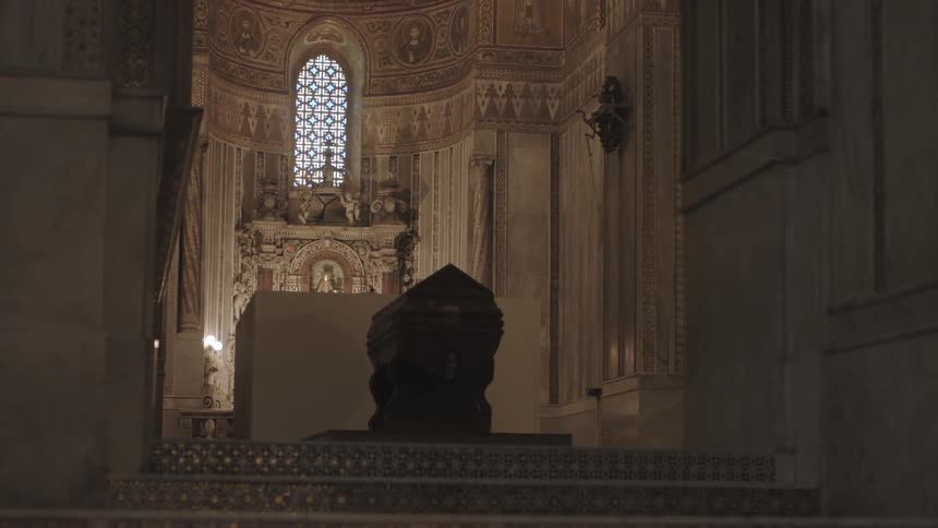 The interior of an ornate church with a painting above an alcove