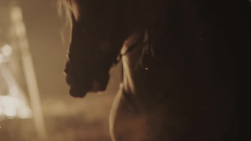A horse being ridden near a fire at night