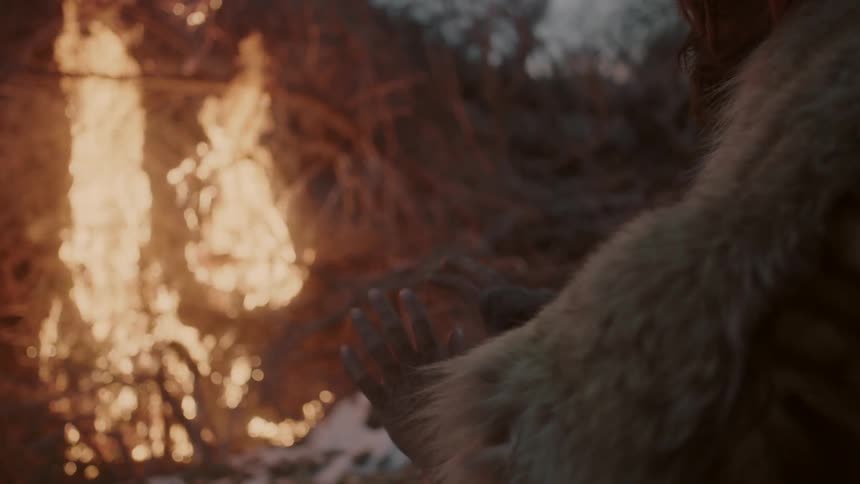 Person warming their hands next to a brushfire