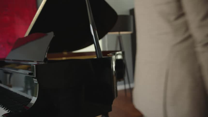 Man walks past piano standing in living room