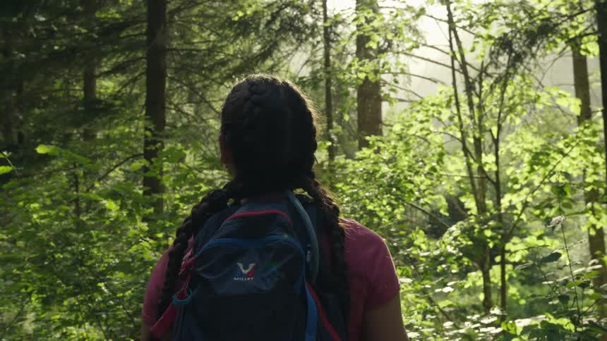 A female is hiking outdoors in a forest