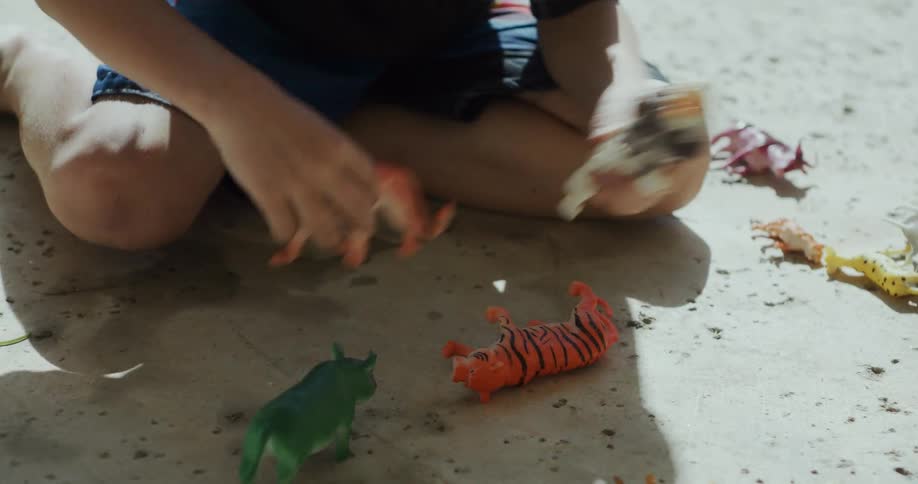 A young white kid is playing with his toys on the beach