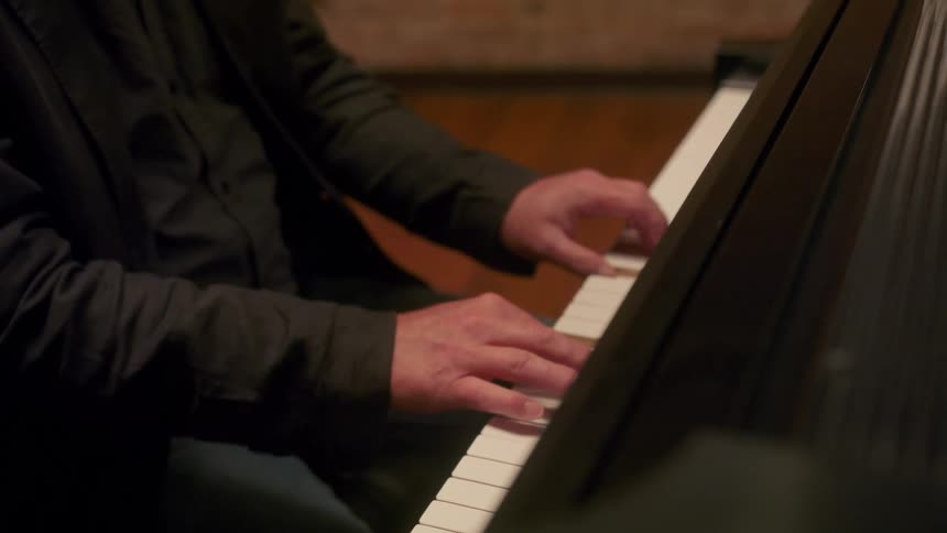 A man in a suit plays the piano