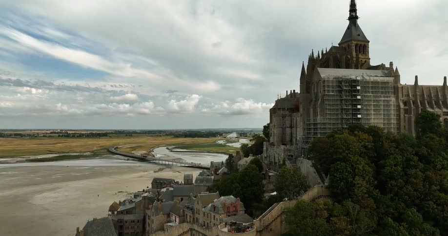 A castle sits on top of a small hill in the middle of an open field
