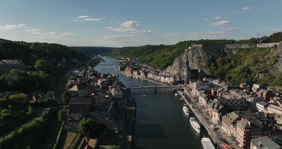 Bridge spans river near cathedral sitting at base of cliffoverlooking town