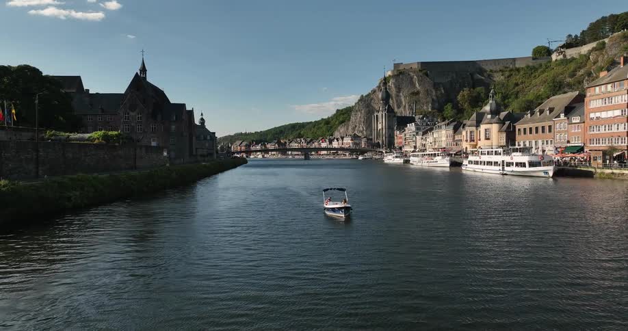 Boats travel along a waterway splitting two halves of a city during the day